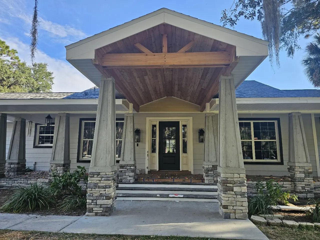 Completed covered front entry with timber ceiling and stone columns